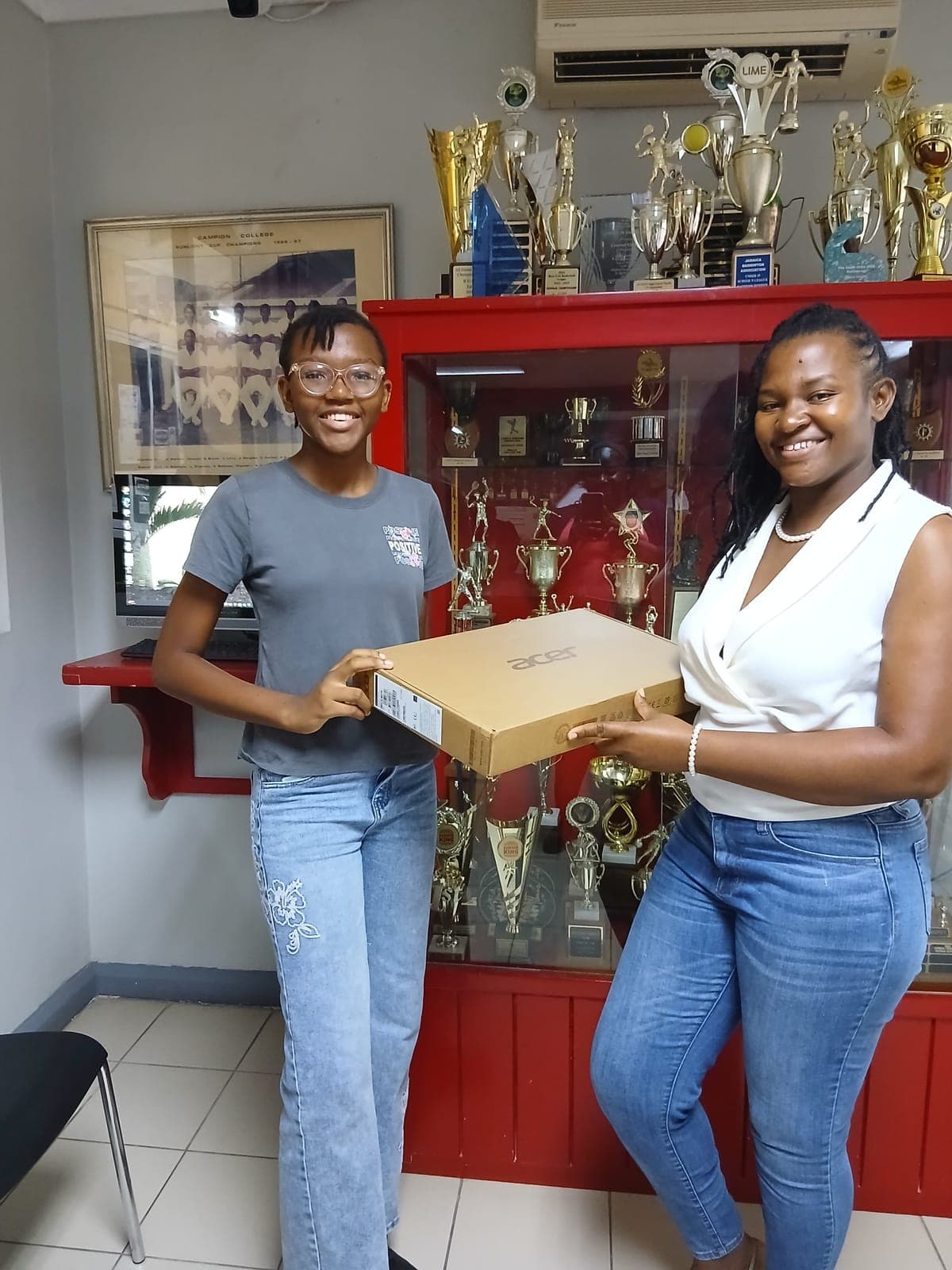 A Campion College student grinning as she is handed her laptop.